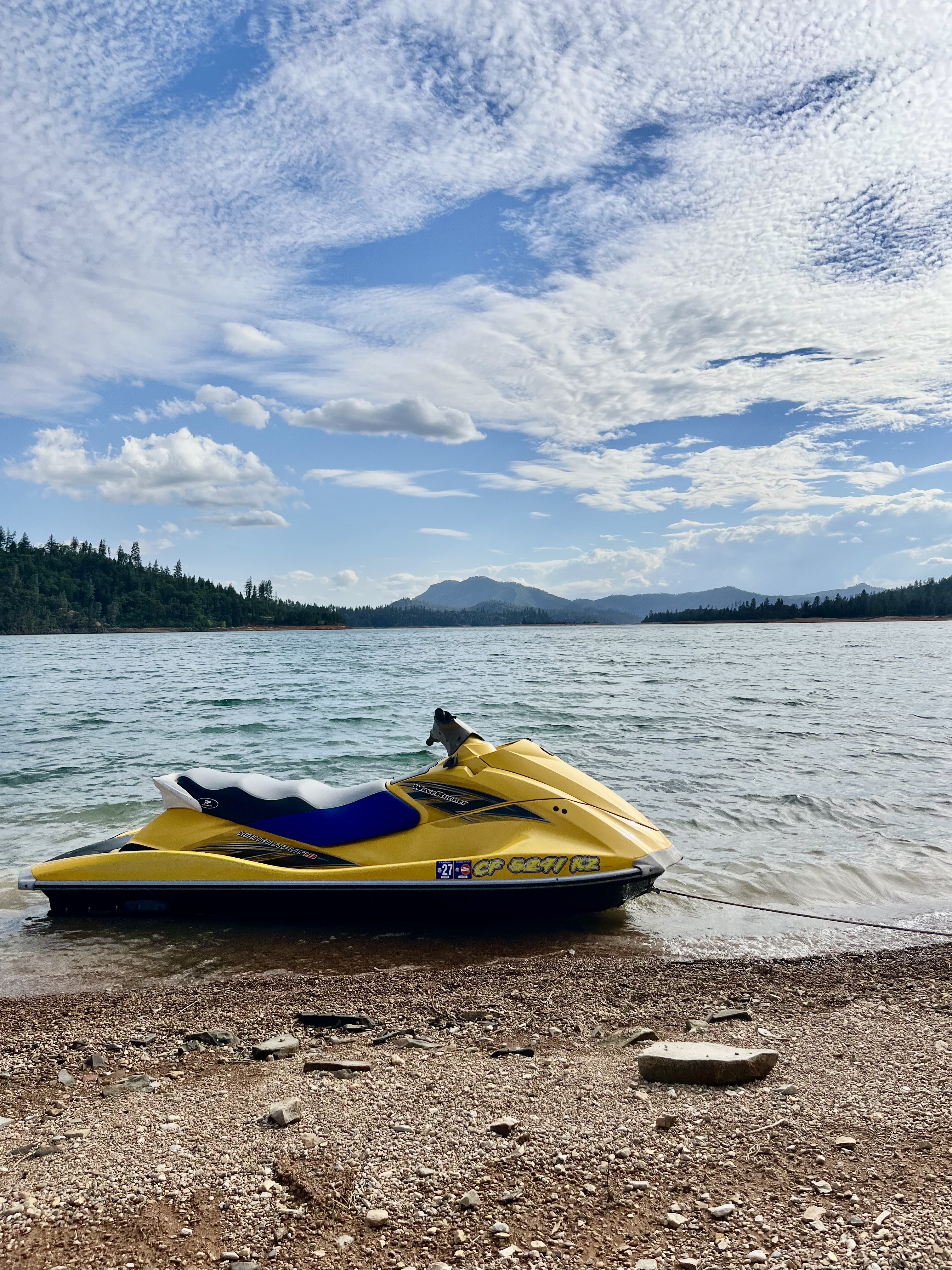 A yellow WaveRunner carving through spray on Lake Shasta